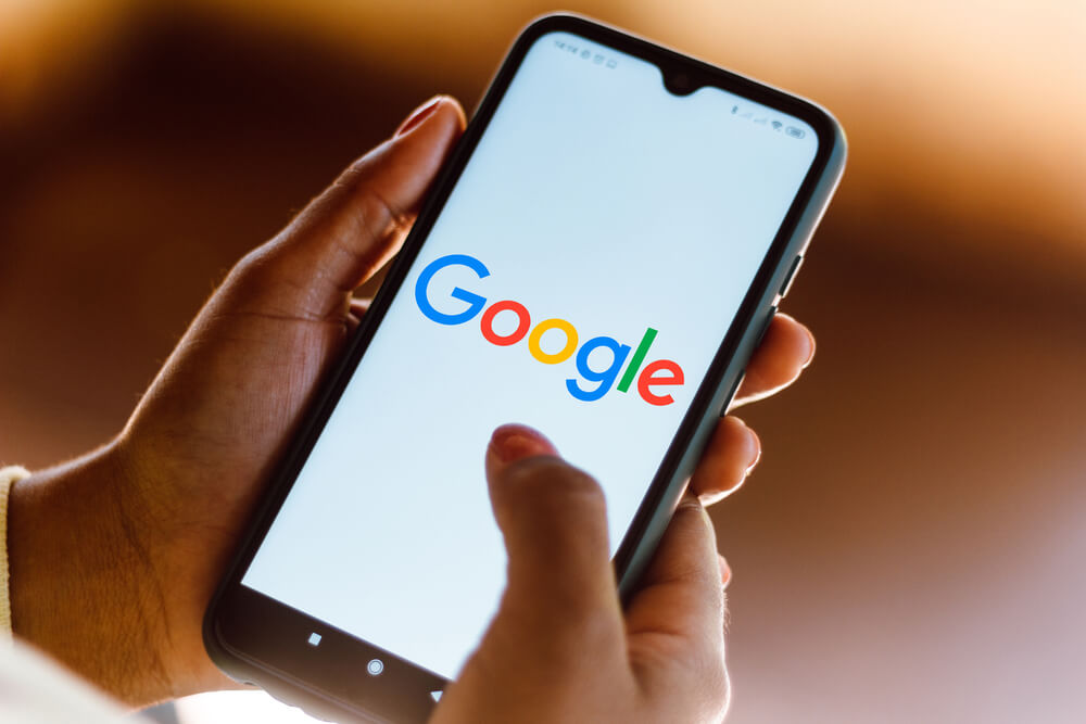 Usuário do Google mexendo no celular para aparecer na primeira página